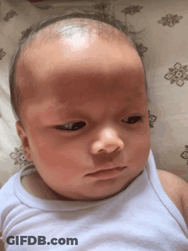 Baby In White Tank Top Lying On Bed GIF