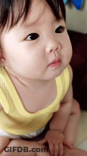 Baby In Yellow Tank Top Looking Up GIF