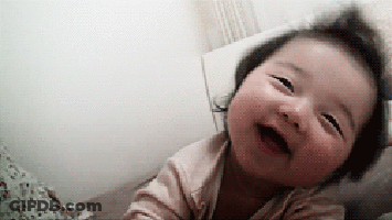 Baby Laying On Bed Making Funny Face GIF