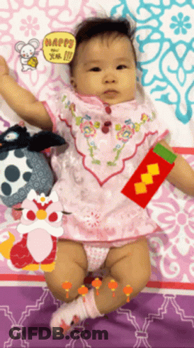Baby Laying On Bed With Happy Sign GIF
