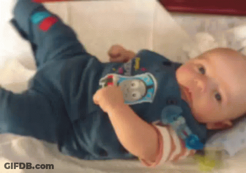 Baby Laying On Bed With Pacifier In Thomas The Tank Engine Shirt GIF