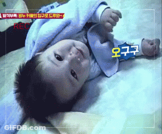 Baby Laying On Bed With Recorder GIF