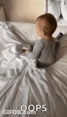 Baby Laying On White Blanket And Pillow GIF