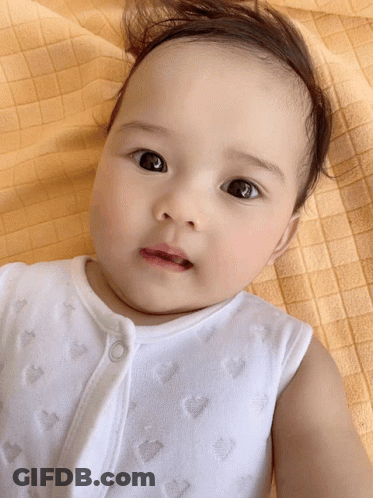 Baby Laying On Yellow Blanket Looking Up GIF