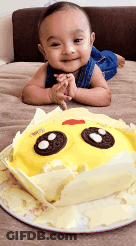Baby Lying Next To Sun-Shaped Cake GIF