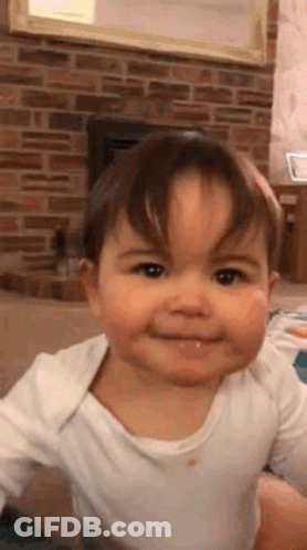 Baby Making Funny Face By Fireplace GIF