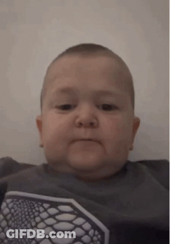 Baby Making Funny Face In Gray Shirt GIF