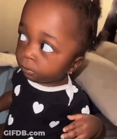 Baby Making Funny Face In Heart Dress GIF