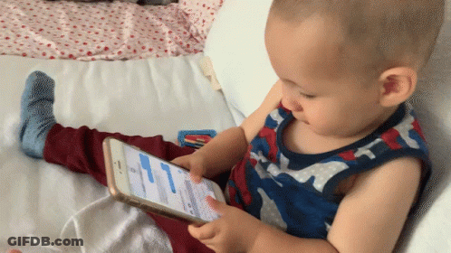 Baby Playing With Cellphone On Bed GIF