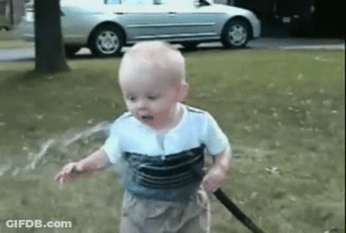 Baby Playing With Hose In Park GIF