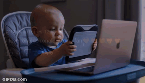 Baby Playing With Tablet And Laptop In High Chair GIF