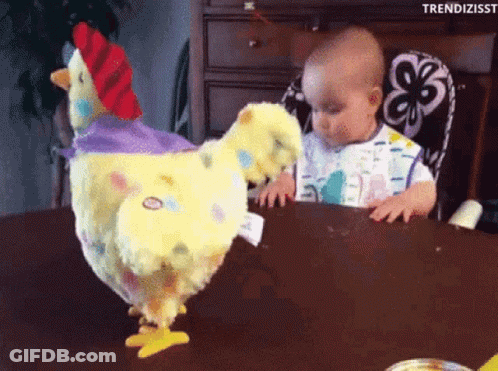 Baby Sitting At Table With Stuffed Chicken GIF