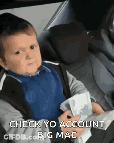 Baby Sitting In Car Seat Holding Money Making Face GIF