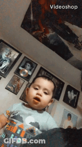 Baby Sitting In Front Of Pictures And Videoshop Logo GIF