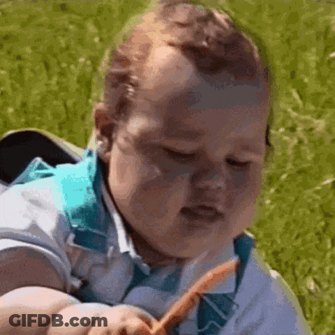 Baby Sitting In Grass Eating Carrot With Eyes Closed GIF