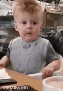 Baby Sitting In High Chair Making Funny Face GIF