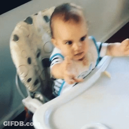 Baby Sitting In High Chair With Spoon In Mouth GIF