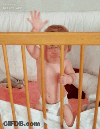 Baby Sitting In Wooden Crib Arms Outstretched GIF