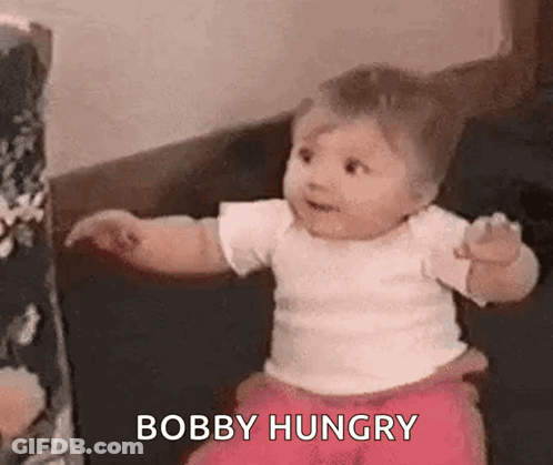 Baby Sitting On Couch Looking At Camera GIF