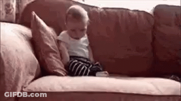 Baby Sitting On Couch With Pillows GIF