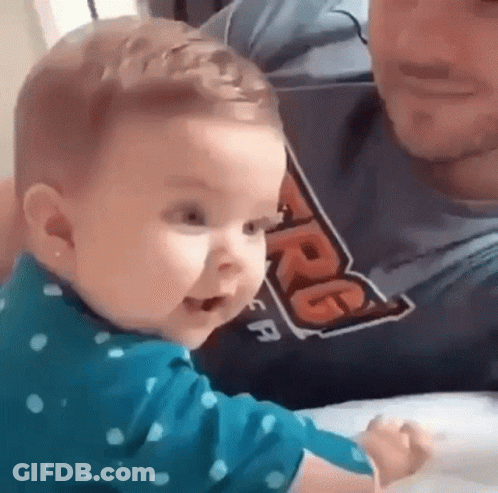 Baby Sitting On Man's Lap Making Funny Face GIF