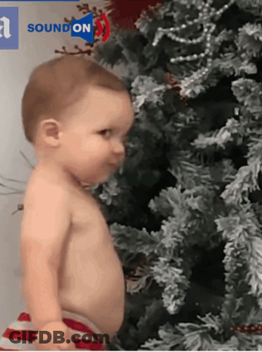 Baby Standing In Front Of Christmas Tree GIF