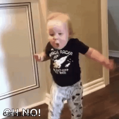 Baby Standing In Hallway Eating With Arms Outstretched GIF