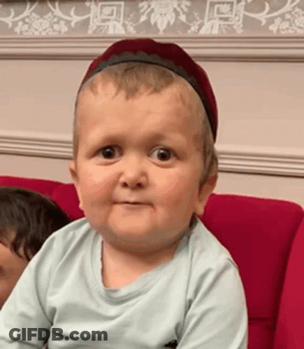 Baby With Headband Making Funny Face Red Couch GIF