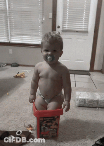 Baby With Pacifier Sitting In Bucket GIF