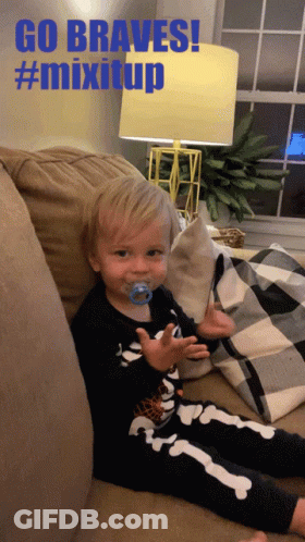 Baby With Pacifier Sitting On Couch Saying Go Braves GIF