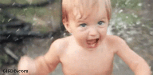Baby Without Shirt In Puddle Smiling GIF