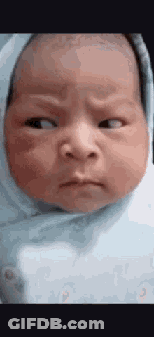 Baby Wrapped In Blue Blanket Making Funny Face GIF