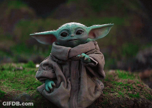 Baby Yoda Figurine Sitting On Mossy Rock GIF