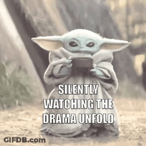 Baby Yoda Holding Cell Phone Silently Watching Drama Unfold GIF