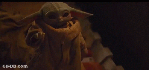 Baby Yoda Looking At Camera On Bed GIF
