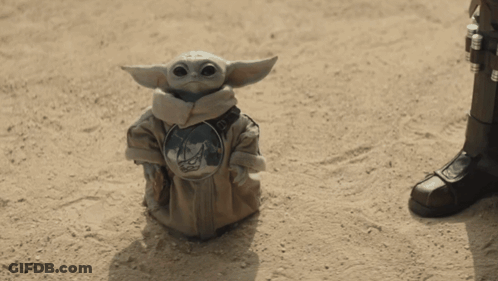 Baby Yoda Statue Sitting On Sand GIF