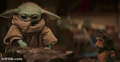 Baby Yoda Toy Sitting On Rock GIF