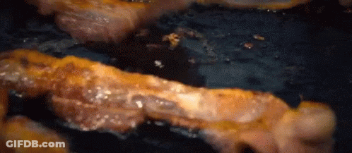 Bacon Is Being Cooked In A Frying Pan On A Stove . GIF