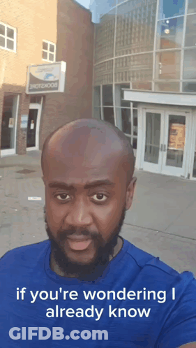 Bald Bearded Man In Front Of Photobook Building GIF