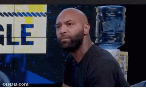 Bald Bearded Man Sitting In Front Of Gle Wall GIF