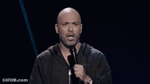 Bald Bearded Man Speaking Into Microphone With Watch GIF