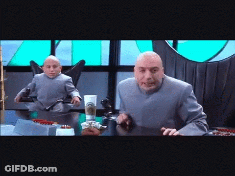 Bald Man At Table With Smaller Man In Chair GIF