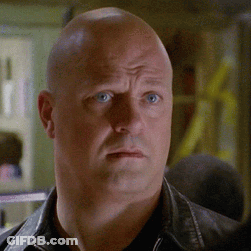 Bald Man Blue Eyes Black Jacket Looking At Camera GIF