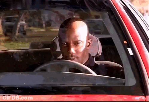 Bald Man Driving Red Car Looking Out Window GIF
