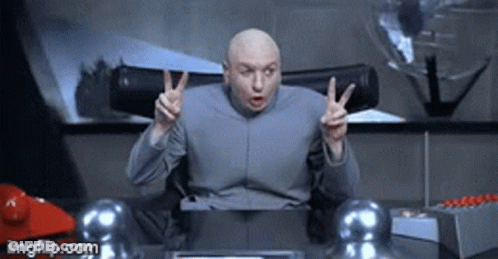 Bald Man Giving Peace Sign At Desk GIF