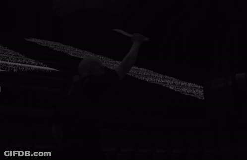 Bald Man Holding Knife In Front Of Screen GIF