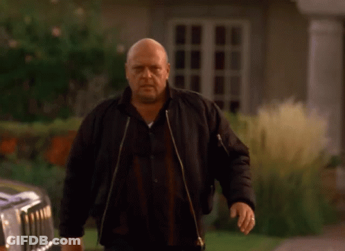 Bald Man In Black Jacket In Front Of House GIF