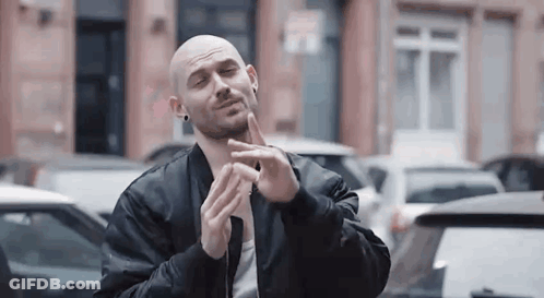 Bald Man In Black Jacket Making Funny Face In Parking Lot GIF