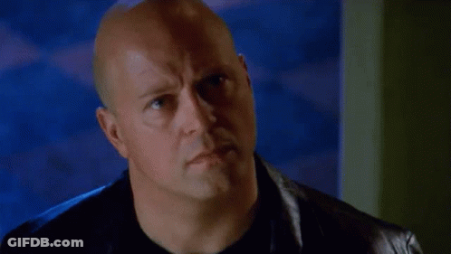Bald Man In Black Shirt And Leather Jacket Looking At Camera GIF