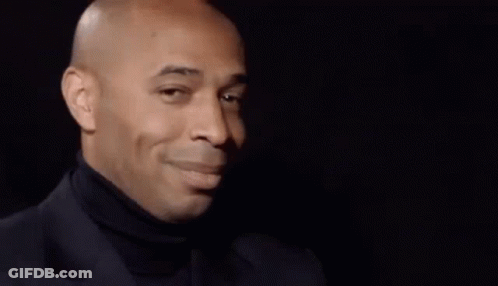 Bald Man In Black Turtleneck And Suit Looking To The Side GIF
